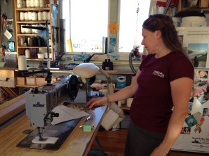 One of the sail makers smudges a temperamental sewing machine.